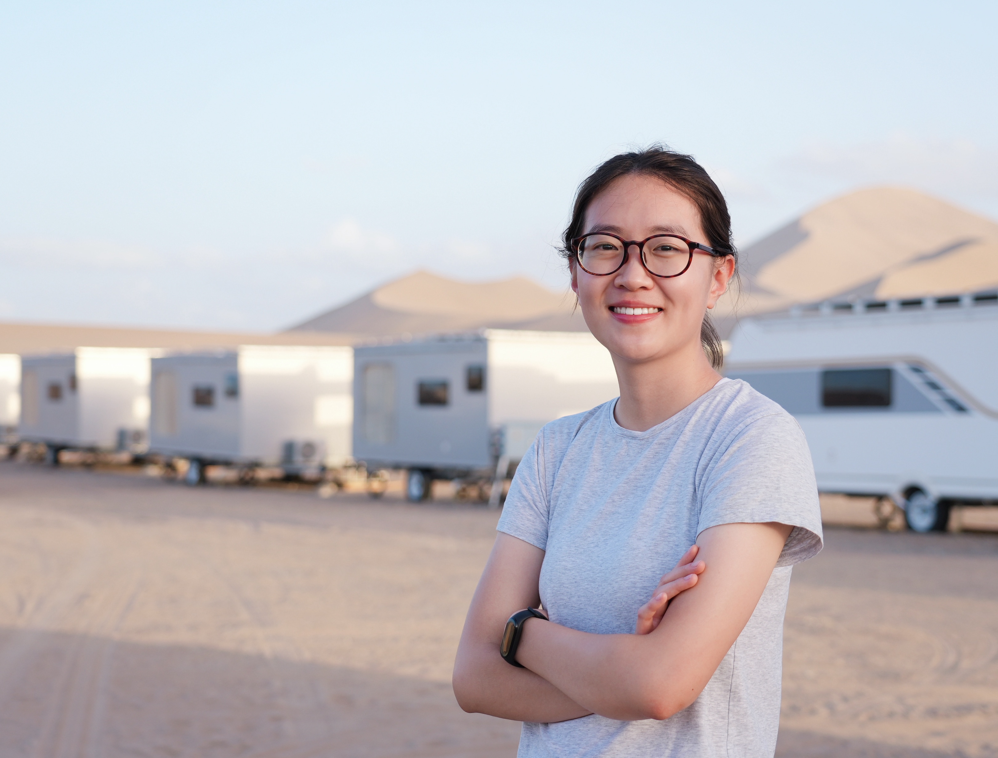 Sabrina's headshot. Sabrina is standing in front of large sand hills.